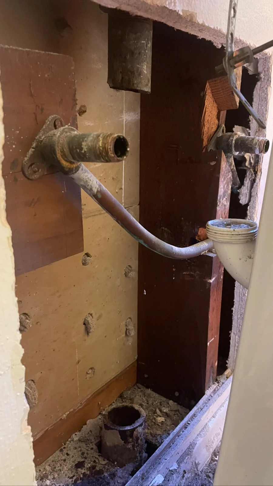 Open wall showing existing sink drain and water lines